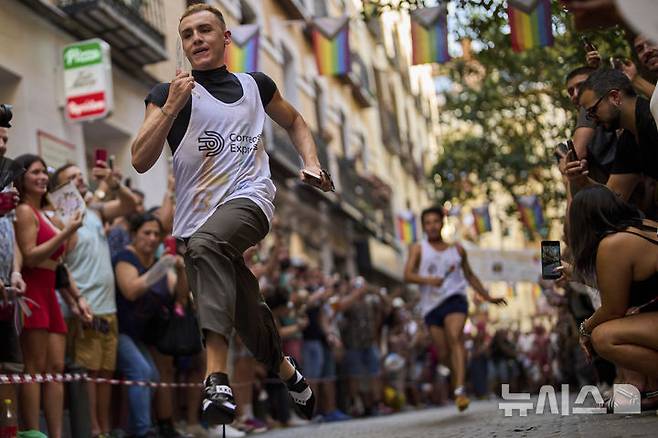 [마드리드=AP/뉴시스] 3일(현지 시간) 스페인 마드리드에서 열린 '마드리드 프라이드 주간의 연례 하이힐 레이스'에 참가한 참가자들이 높이 15cm의 하이힐을 신고 달리고 있다. 2025.07.04.