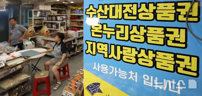 [서울=뉴시스] 김선웅 기자 = 국회 행정안전위원회가 13조2000억원 규모의 '민생회복 소비쿠폰' 지급 관련 추가경정예산안(추경안)을 의결했다. 기존 정부안은 중앙·지방정부 공동 예산 분담 구조였으나 국회는 이를 전액 국비로 전환해 지방 재정의 부담을 덜었다. 또한 지역화폐(지역사랑상품권) 예산 6000억원 규모의 추경안도 원안대로 통과됐다.쿠폰은 지역사랑상품권 등 지역화폐, 선불카드, 신용·체크카드 포인트 중에서 선택 가능하며 소득에 따라 15~50만원을 지급 받을 수 있다. 사진은 2일 서울 소재 전통시장 내 지역화폐 결제 가능 매장의 모습. 2025.07.02. mangusta@newsis.com
