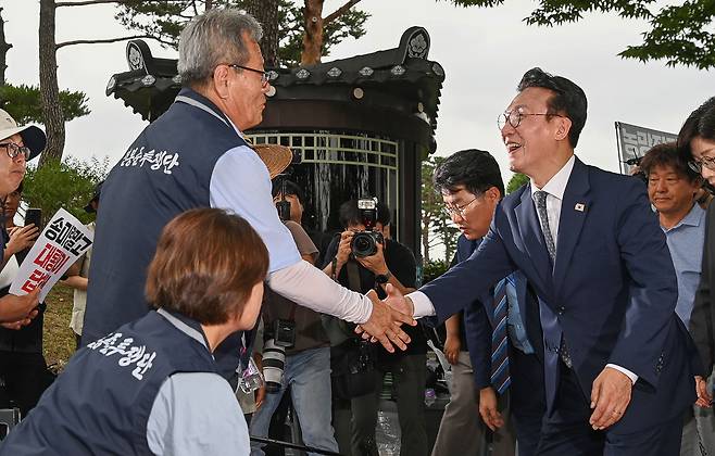 김민석 국무총리가 취임 후 첫 일정으로 4일 서울 용산 대통령실 앞에서 항의 농성 중인 농민단체를 방문해 인사를 나누고 있다.