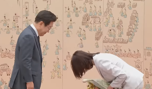 이재명 대통령에게 꽃다발을 받은 김민석 신임 국무총리의 아내가 인사를 하고 있다. 사진=KTV 이매진 캡쳐