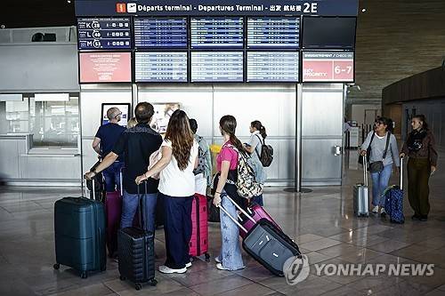 3일(현지시간) 파리 샤를 드골 공항에서 항공편 스케줄 안내판 바라보는 승객들 [EPA 연합뉴스 자료사진. 재판매 및 DB 금지]