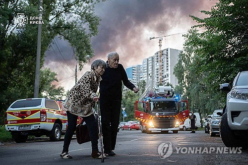 3∼4일 사이 러시아 공습 받은 키이우에서 두 노인이 길을 지나는 모습. [젤렌스키 대통령 엑스(X·옛 트위터) 캡처. 연합뉴스]