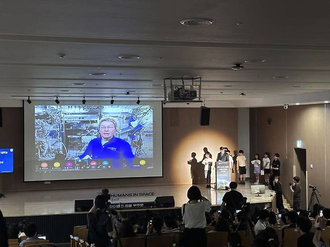 [서울=뉴시스] 초등학생과 페기 윗슨이 실시간으로 질의응답을 하는 모습. 보령은 연세대학교 미래교육원 대강당에서 국제우주정거장(ISS)과 연결되는 'Humans In Space(HIS) Youth 수상작 우주정거장 발표 생중계' 행사를 개최했다. (사진=보령 제공) 2025.07.05. photo@newsis.com *재판매 및 DB 금지