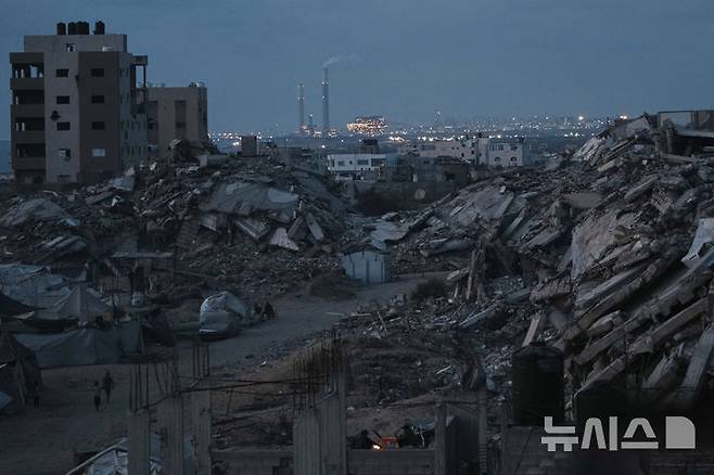 [가자지구=AP/뉴시스] 2일(현지시간) 가자지구에서 이스라엘의 공습과 지상 공격으로 인해 쫓겨난 팔레스타인인들이 부서진 건물 사이를 걷고 있다. 2025.06.03