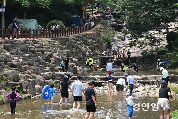 낮 최고기온이 33도까지 상승하는 등 무더운 날씨가 이어진 6일 오후 과천시 관악산 계곡을 찾은 시민들이 물놀이를 하며 더위를 식히고 있다. 2025.7.6 /최은성기자 ces7198@kyeongin.com