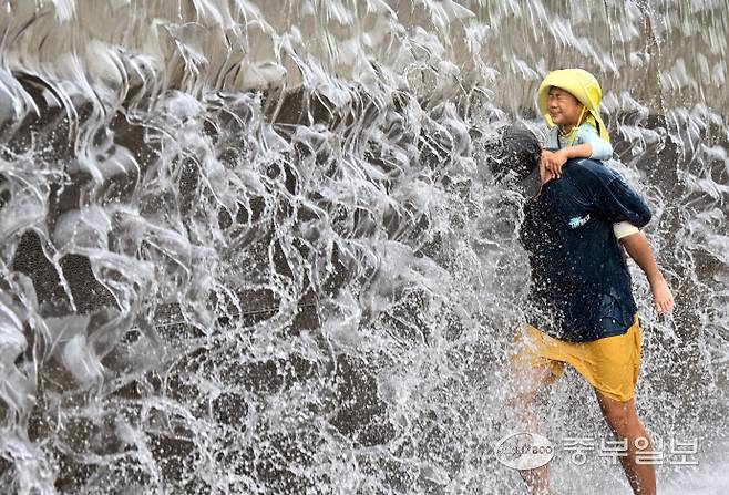 전국 대부분 지역에 폭염 특보가 내려진 6일 오후 수원시 영통구 광교호수공원 신비한 물너미에서 가족들이 시원한 낙수를 맞으며 더위를 식히고 있다. 김경민기자