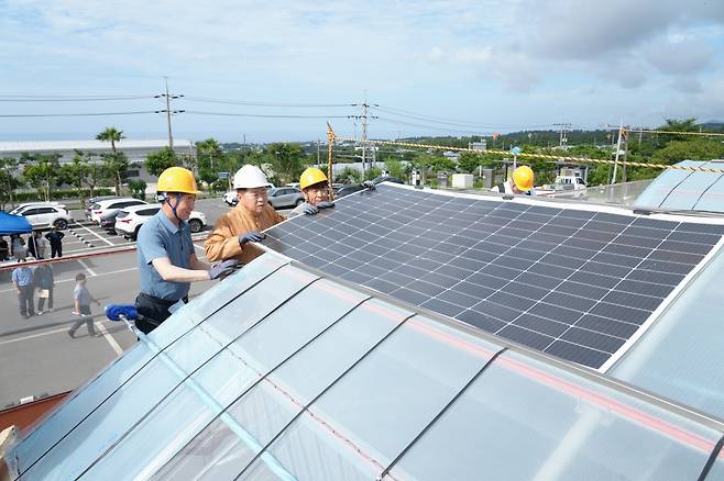 오영훈 지사가 지난 5일 농업기술원을 방문해 RE100 감귤 생산 모델 실증을 위한 필름형 태양광 패널 설치 작업에 참여하고 있다.