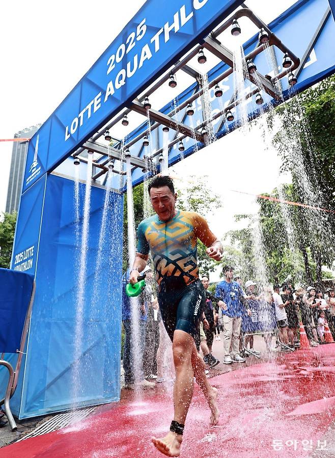 6일 서울 송파구 석촌호수 동호에서 열린 ‘2025 롯데 아쿠아슬론’ 참가자들이 수영을 마치고 롯데월드타워 1층부터 123층까지 2,917개의 계단을 오르는 수직 마라톤 스카이런(SKY RUN) 코스를 향해 달려가고 있다. 양회성 기자 yohan@donga.com