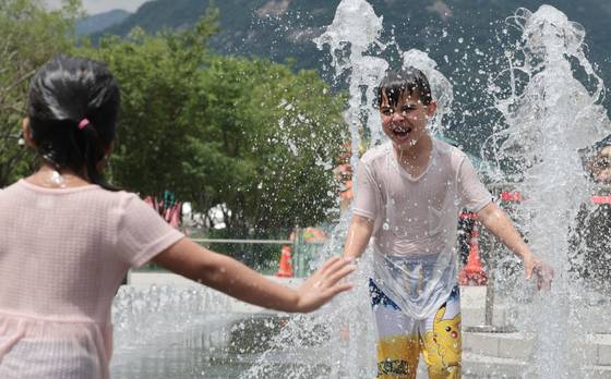 무더운 날씨 이어지면서 전국 대부분 지역에 폭염특보가 발효된 1일 서울 광화문광장 바닥분수대에서 한 외국인 어린이가 즐거운 시간을 보내고 있다. 연합뉴스