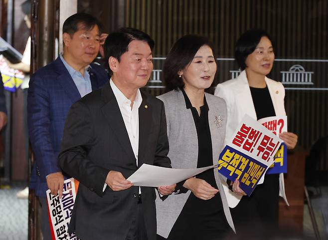 Rep. Ahn Cheol-soo (center left), who was tapped to head the People Power Party's Innovation Committee, walks through the Rotender Hall of the National Assembly in Yeouido, Seoul, on Thursday, holding pickets with fellow lawmakers to protest the confirmation of then-Prime Minister nominee Kim Min-seok. (Yonhap)