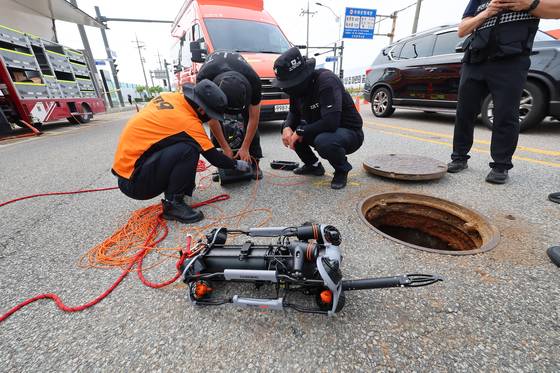 Officials search inside a manhole on July 6 in Incheon in search of a worker who went missing earlier in the day. [YONHAP]