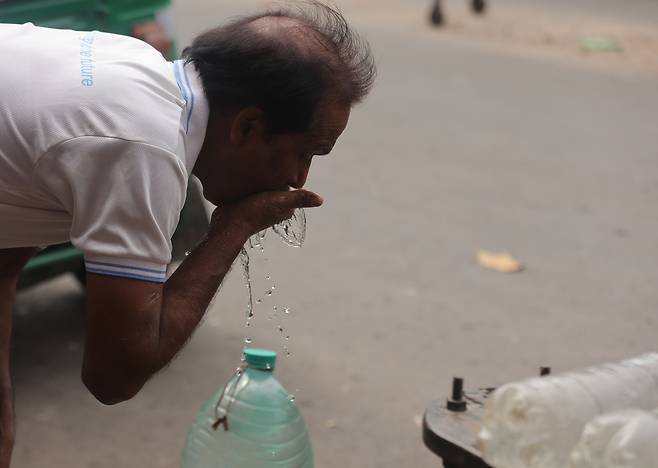 지난달 11일, 인도 콜카타에서 한 통근자가 폭염 속 교통체증 중에 물을 마시고 있다. 인도 기상청(IMD)에 따르면, 서벵골 지역에 폭염이 계속되면서 기온이 최고 40도까지 오를 것으로 예보됐다.[EPA]