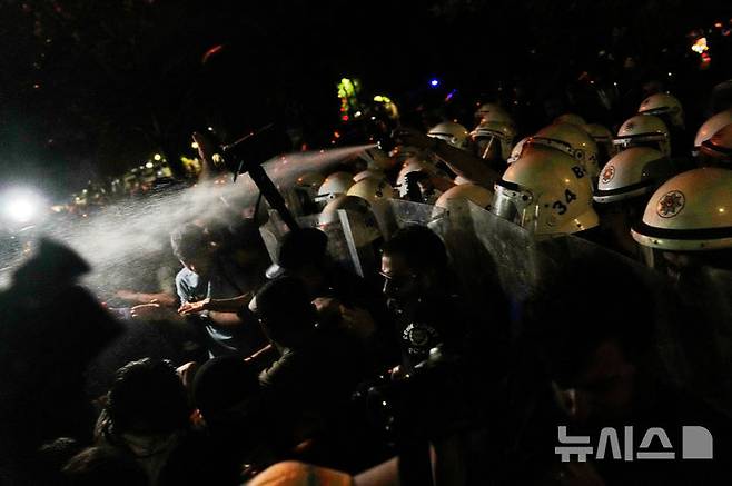 [이스탄불=AP/뉴시스] 7월1일 튀르키예 이스탄불 시청 앞에서 경찰이 제1야당인 공화인민당(CHP) 주도한 반정부 시위 참여 대학생들에게 최루액을 분사하고 있다. 2025.07.06.