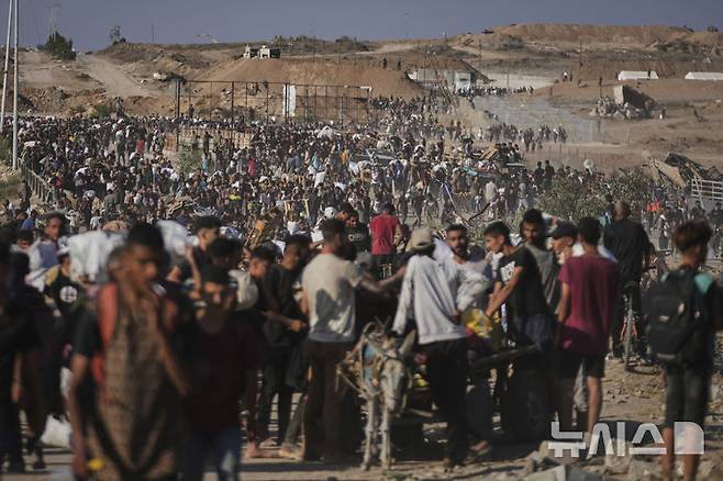 [칸유니스=AP/뉴시스] 6월26일 가자지구 남부 칸유니스에서 팔레스타인 주민들이 미국이 주도하는 구호단체 가자인도주의재단(GHF)이 배포한 구호 물품을 받아 나르고 있다. 2025.06.27.