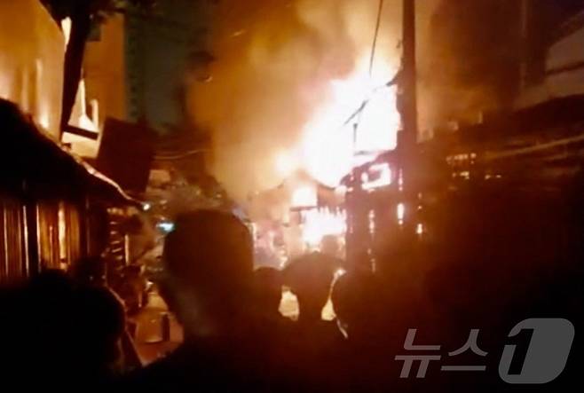 6일(현지시간) 밤 베트남 호치민시의 한 아파트에서 발생한 화재를 주민들이 안타깝게 지켜보고 있다. 이 화재로 어린이 2명을 포함해 모두 8명이 숨졌다. 2025.07.06. ⓒ AFP=뉴스1 ⓒ News1 윤다정 기자