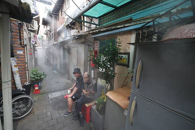7일 오후 서울 종로구 돈의동 쪽방촌에서 주민들이 쿨링포그 아래에 앉아 더위를 식히고 있다. 김영원 기자 forever@hani.co.kr