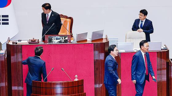 문진석 더불어민주당 원내수석부대표(의장석 앞 왼쪽부터), 송언석 국민의힘 비상대책위원장 겸 원내대표, 유상범 원내수석부대표가 4일 오후 서울 여의도 국회에서 제426회국회(임시회) 제5차 본회의 개의 지연 관련 우원식 의장과 대화한 뒤 자리로 향하는 모습. 뉴스1