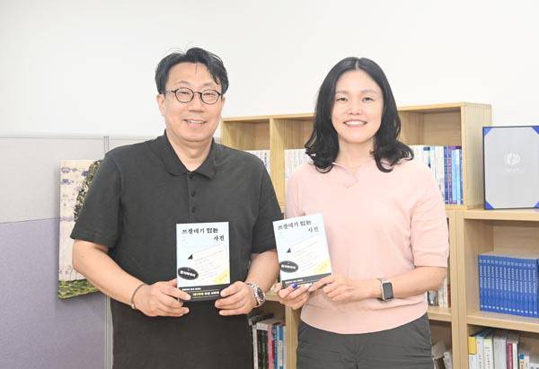 양민호(사진 왼쪽) 최민경 교수가 공저한 부산 사투리에 관한 책 ‘쓰잘데기 있는 사전’을 들어보이고 있다.  국립부경대 제공