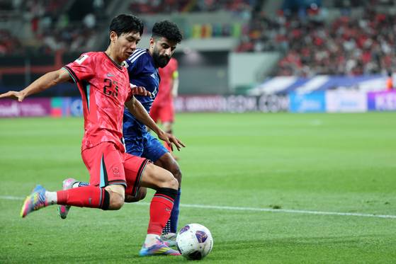Korea's Jeon Jin-woo, left, vies for the ball during a 2026 World Cup qualifier against Kuwait at Seoul World Cup Stadium in western Seoul on June 10. [NEWS1]