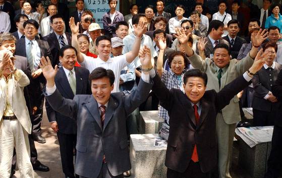 Then liberal presidential candidate Roh Moo-hyun, right, and Seoul mayoral candidate Kim Min-seok cheer at a party rally in Myeong-dong, central Seoul, on May 28, 2002. [YONHAP]