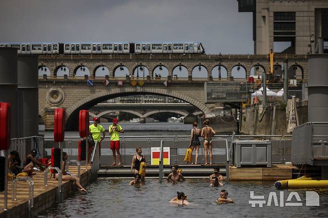 <font style="vertical-align: inherit;"><font style="vertical-align: inherit;">[파리=AP/뉴시스] 5일(현지 시간) 프랑스 파리 센 강 베르시에서 시민들이 수영을 하고 있다. 센 강은 100여 년 만에 공공 수영 공간으로 개방됐다. 마리 수로, 베르시 강변, 그르넬 항구 근처 등 세 곳이 야외 수영 구역으로 지정됐으며 오는 8월 31일까지 무료로 개방된다. 탈의실, 샤워 시설, 파라솔, 비치체어 등이 갖춰졌다. 2025.07.07.</font></font>