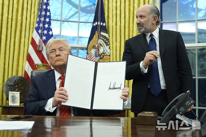[워싱턴=AP/뉴시스] 도널드 트럼프 미국 대통령이 10일(현지 시간) 백악관 집무실에서 철강과 알루미늄 제품 관세 부과에 관한 포고문에 서명한 후 이를 들어 보이고 있다. 트럼프 대통령은 이번 관세에 "예외나 면제 없다"라고 밝혔다. 2025.02.11.
