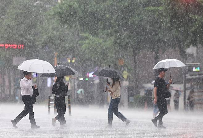 소나기가 내리는 8일 오후 서울 종로구 종각역 인근에서 우산을 쓴 시민들이 발걸음을 재촉하고 있다./뉴스1