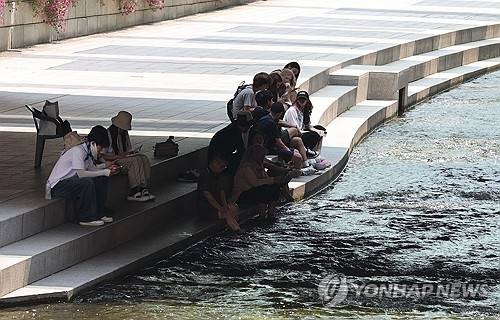 낮 최고기온이 36도로 예보된 8일 서울 청계천 모전교 아래 그늘에서 시민들이 휴식을 취하고 있다. [연합뉴스]