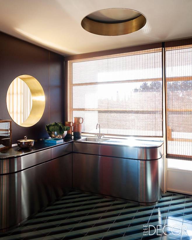 발코니와 맞닿은 넓고 쾌적한 주방. 식당을 향해 있는 둥근 창과 디모레밀라노(Dimoremilano)의 천장 조명에서도 해양적 요소를 발견할 수 있다.