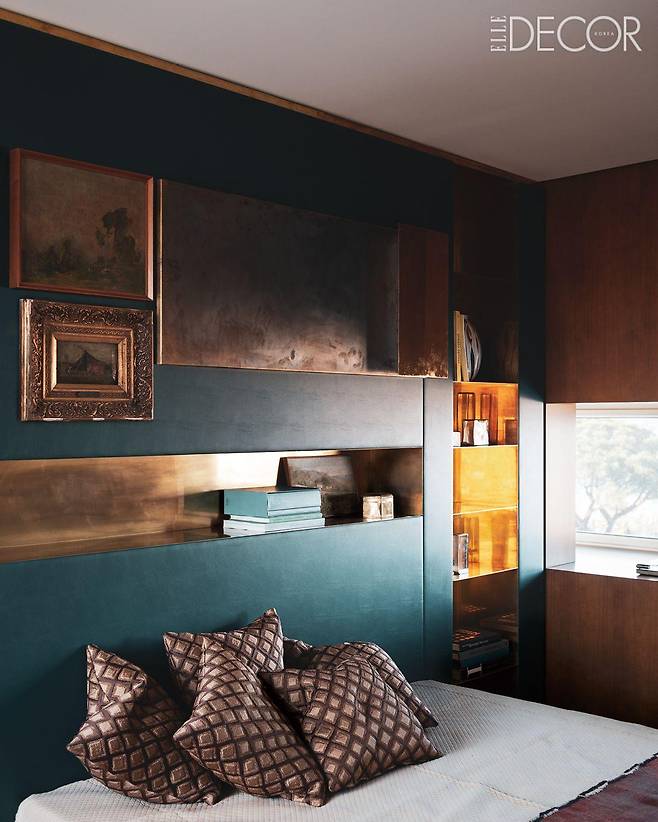 청색 가죽 헤드보드 침대가 놓인 마스터 베드룸의 모습.