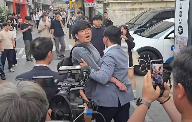 2025년 5월29일 이준석 당시 대선 후보가 유세하던 서울 성북구 안암동 고려대 앞에서 한 청년이 “당신이 어떻게 청년 남성을 대표할 수 있습니까”라고 소리치자 현장 관계자들이 저지하고 있다. 유튜브 채널 미디어몽구 갈무리