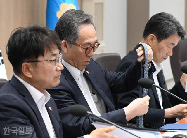 8일 대통령실에서 열린 국무회의에 참석한 조태열(가운데) 외교부 장관이 복장이 노타이 차림이라는 사실을 뒤늦게 알고 넥타이를 풀고 있다. 왕태석 선임기자