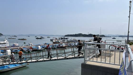 7일 오전 충남 태안 영목항에서 진행된 선박 화재 가상 훈련에서 해경과 군(軍) 장병이 불을 끄기 위해 계류장으로 달려가고 있다. [사진 태안해경]