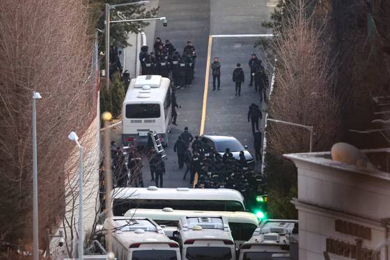 Police officers carry a ladder outside the presidential residence in Hannam-dong, Yongsan District, on January 15, 2025, as the Corruption Investigation Office for High-ranking Officials (CIO) and police move to execute a second arrest warrant for then President Yoon Suk Yeol. [YONHAP]
