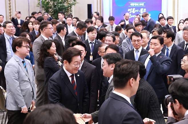 President Lee Jae Myung, center, greets reporters after his first formal press conference marking 30 days IN office at the Blue House compound in central Seoul on July 3. [JOINT PRESS CORPS]