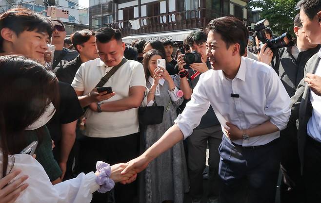 Lee Jun-seok, the minor Reform Party's candidate in the June presidential election, shakes hands during a campaign event in Jongno District, central Seoul, on May 25. According to a joint exit poll by terrestrial broadcasters KBS, MBC and SBS, over a third of men in the 20s voted for him compared to just 4 percent of women in the same age group. [NEWS1]