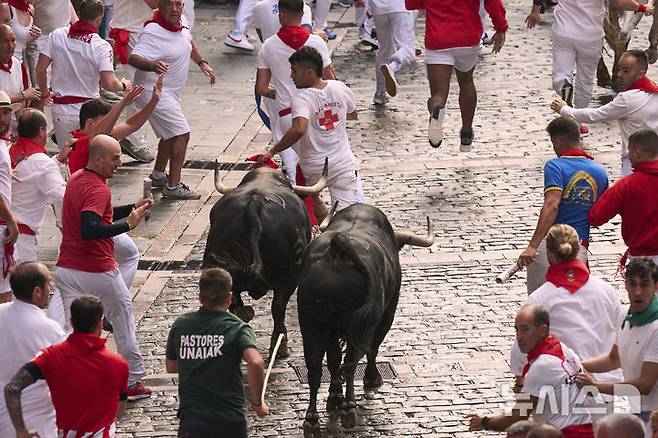 [팜플로나=AP/뉴시스] 7일(현지 시간) 스페인 팜플로나에서 열린 연례 산 페르민 축제 중 황소와 달리기(엔시에로) 참가자들이 골목길을 달리고 있다. 2025.07.07.