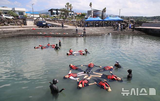 [서귀포=뉴시스] 우장호 기자 = 8일 오전 제주 서귀포시 법환 해녀체험장에서 제주도교육청과 해녀·해군기동함대사령부가 협동해 강정초등학교 학생들에게 '제주형 생존수영' 교육을 하고 있다. 이번 생존수영 교육은 법환 어촌계 해녀, 해군 해난구조대(SSU)가 함께하는 전국 최초의 프로그램으로 서귀포시 관내 초등학교 5~6학년 학생 100여명(3개교)을 대상으로 8월15일까지 운영된다. 2025.07.08. woo1223@newsis.com