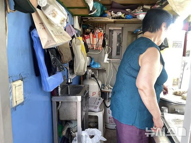 [서울=뉴시스]이채은 인턴기자=8일 폭염경보가 발효 중인 서울 영등포역 인근 노점상에서 한 상인이 옥수수를 팔고 있다. 2025.07.08