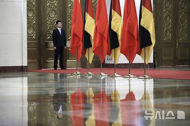 [베이징=AP/뉴시스]2018년 5월24일 베이징 인민대회당에서 열린 독일과 중국 정상회담에서 한 경호원이 중국과 독일 국기 옆에서 경계를 서고 있다. 독일 외무부는 8일 중국 군함이 홍해에서 독일 항공기에 레이저를 발사한 것과 관련, 베를린 주재 중국 대사를 외무부로 불러 항의했다고 밝혔다. 2025.07.08.