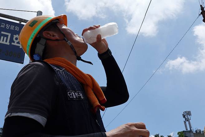 한 건설노동자가 더위를 달래기 위해 얼음물을 마시고 있다. 연합뉴스