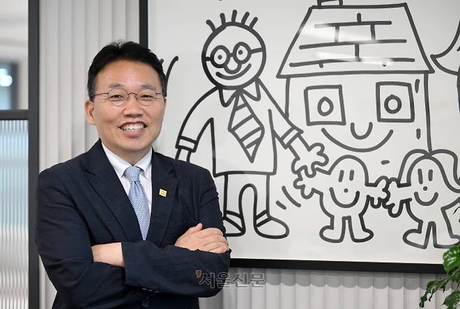 정익중 아동권리보장원장이 지난달 19일 아동권리보장원장실에 걸려 있는 영국의 팝아티스트 미스터 두들이 2019년 가정위탁의 날 행사에서 그린 그림 앞에서 포즈를 취하고 있다. 홍윤기 기자