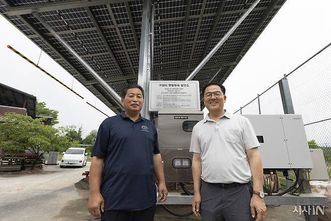 6월18일 경기도 여주시 구양리 전주영 이장(왼쪽)과 최재관 더불어민주당 여주시·양평군 지역위원장이 마을 풋살장에 설치한 햇빛두레 발전소 앞에 섰다. 구양리는 마을 자산 총 6곳에 태양광발전소를 설치해 한 달에 1000만원 수준의 발전 수익을 내고 있다. ⓒ시사IN 이명익