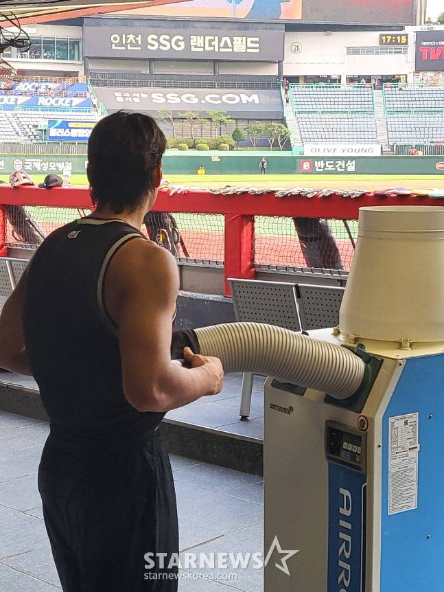 KT 장진혁이 8일 인천 SSG랜더스필드에서 훈련을 마치고 이동식 에어컨 앞에 붙어 열기를 식히고 있다. /사진=안호근 기자