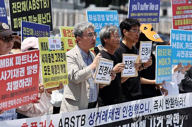 '홈플러스 전단채 피해자' 진정서 제출  기자회견 (서울=연합뉴스) 윤동진 기자 = 12일 서울 전쟁기념관 앞에서 열린 '홈플러스 전단채 사기발행 사건 관련, MBK 엄벌과 피해회복을 위한 진정서 제출 기자회견'에서 홈플러스 물품 구매 전단채 피해자 비상대책위원회 등 참석자들이 관련 내용이 적힌 피켓을 들고 있다. 2025.6.12 mon@yna.co.kr