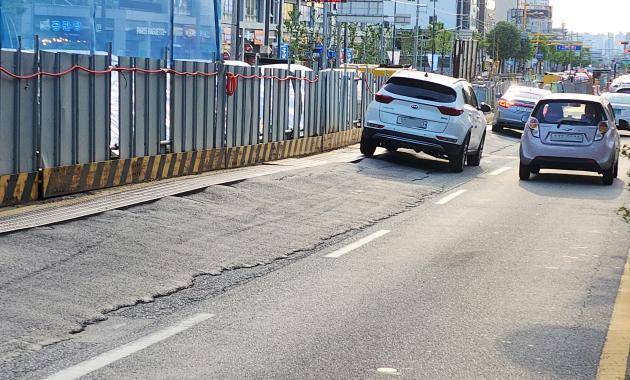 9일 광주시 북구 필문대로 광주교대 앞 도시철도 2호선 공사현장에서 기울어진 도로 위를 차량이 주행하고 있다. 복공판이 설치된 도로의 단차가 매우 큰데다 포장 상태도 엉망이다. /나명주 기자 mjna@kwangju.co.kr