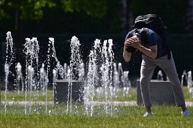 독일 베를린의 분수대에서 한 남성이 물로 머리를 헹구고 있다.(사진=AFP)