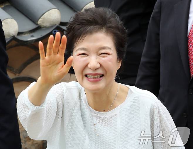 박근혜 전 대통령이 2일 부산 금정구 범어사를 방문해 주지 정오스님과 대웅전으로 향하며 지지자들에게 인사하고 있다. 2025.6.2/뉴스1 ⓒ News1 윤일지 기자