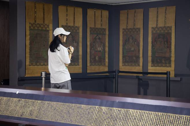 8일 국립고궁박물관에서 공개된 고려 사경 ‘감지금니 대방광불화엄경 주본 권22’(앞)와 조선 전기 불화 ‘시왕도’. /연합뉴스