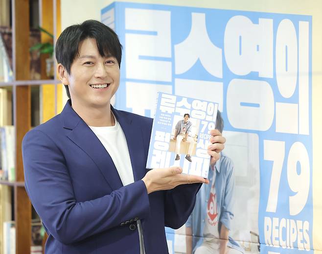 배우 류수영이 8일 서울 중구 정동 프란치스코교육회관에서 열린 '류수영의 평생 레시피' 출간 기념 기자간담회에서 취재진을 향해 책을 들어보이고 있다./연합뉴스